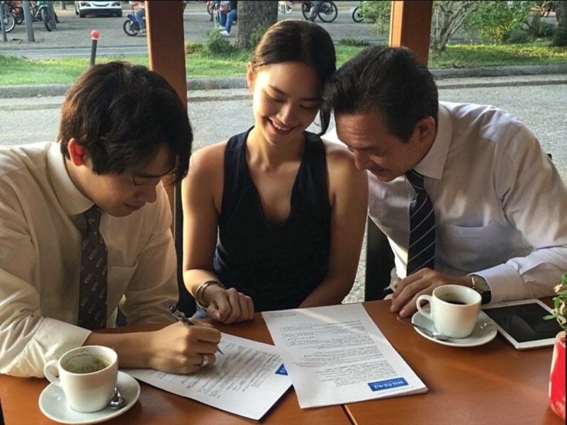 Clients signing their new policies at a cafe table